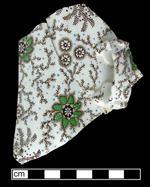 Pitcher or jug printed undr the glaze in brown, with blue & green overglazeenamelled decoration.